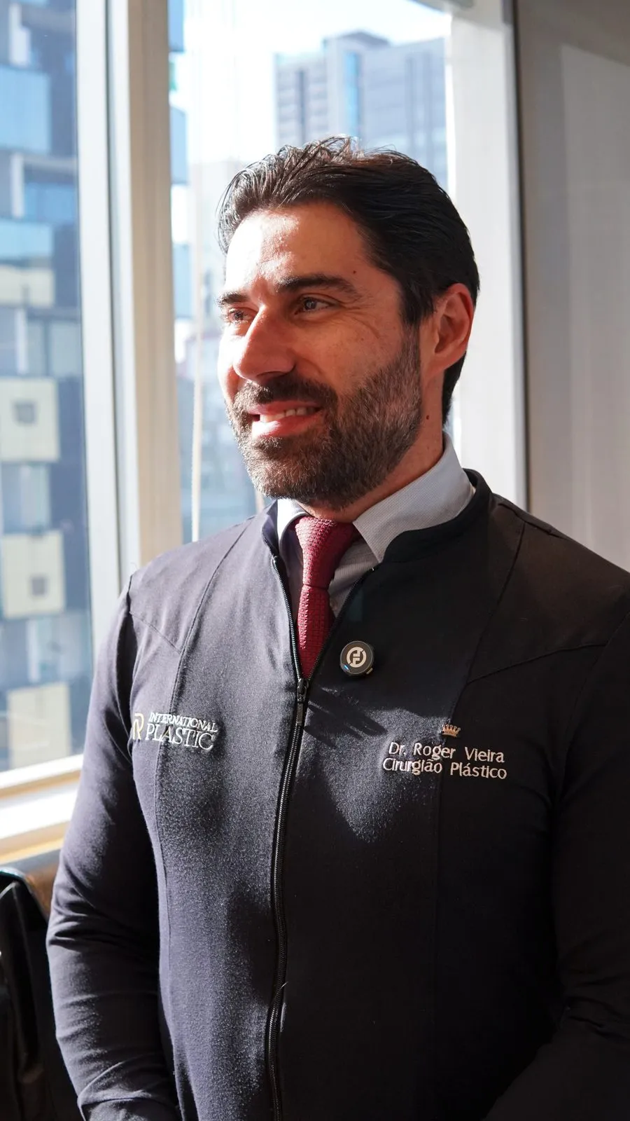Dr. Roger Vieira smiling, in the clinic uniform